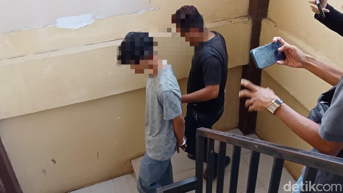 Pelaku saat diserahkan ayah korban ke Polrestabes Palembang.
