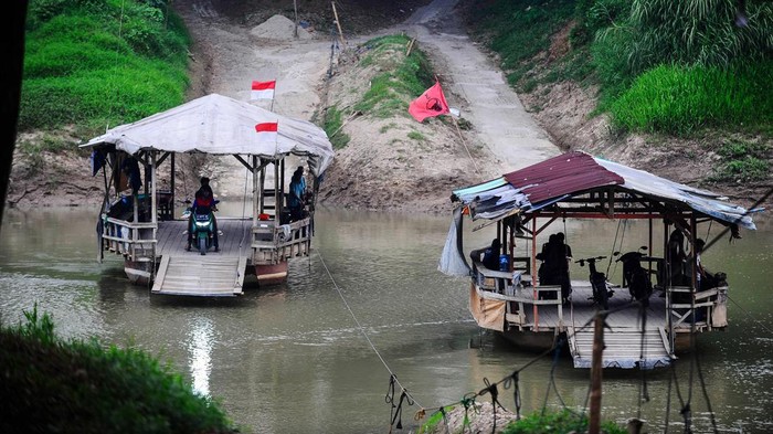 Warga menggunakan perahu eretan menyeberangi sungai Ciujung di Pamarayan, Kabupaten Serang, Banten, Minggu (9/6/2024). Warga setempat memanfaatkan jasa penyeberangan perahu eretan sebagai jalur alternatif untuk mempersingkat jarak tempuh dengan tarif berkisar Rp2.000 untuk sekali penyeberangan. ANTARA FOTO/Muhammad Bagus Khoirunas/Spt.