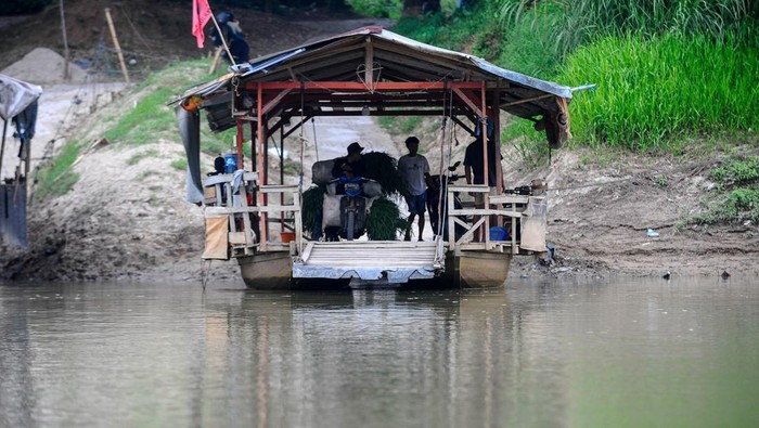 Warga menggunakan perahu eretan menyeberangi sungai Ciujung di Pamarayan, Kabupaten Serang, Banten, Minggu (9/6/2024). Warga setempat memanfaatkan jasa penyeberangan perahu eretan sebagai jalur alternatif untuk mempersingkat jarak tempuh dengan tarif berkisar Rp2.000 untuk sekali penyeberangan. ANTARA FOTO/Muhammad Bagus Khoirunas/Spt.