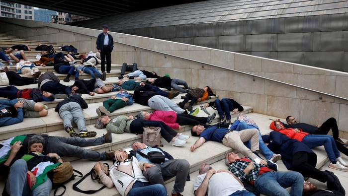 Protesters lay on the ground outside Bilbao's Guggenheim Museum of modern art to mimic casualties in Gaza, during a protest organised by the Gernika-Palestina collective from the Basque region of Spain, amid the Israel-Hamas conflict, in Bilbao, Spain, June 8, 2024. REUTERS/Vincent West
