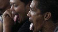 Tampak peserta yang mulai mulai merasakan pedas dengan menjulurkan lidahnya.  