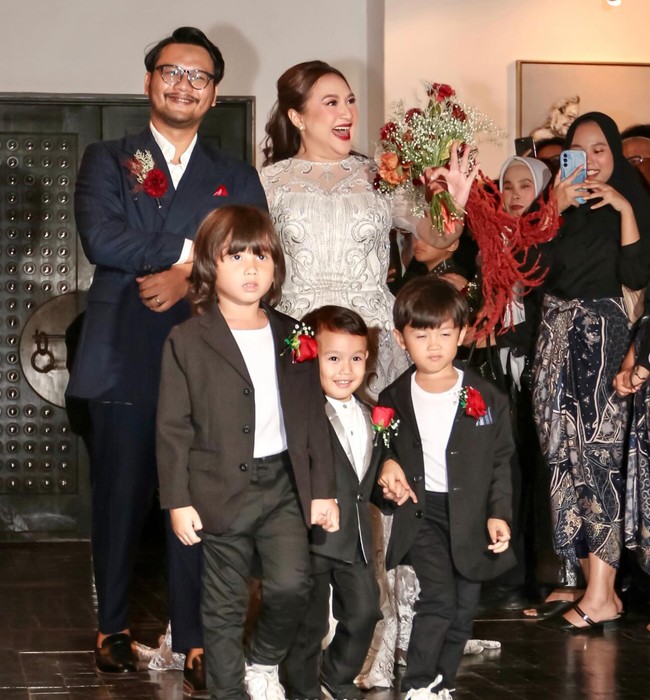 Chika dan suaminya, Daffa, tampil kompak dan mesra. Chika memilih mengenakan dress panjang berwarna putih, sementara suaminya mengenakan setelan jas berwarna biru tua. Foto: Instagram/@irawbw