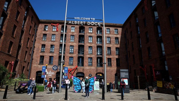 People walk near banners displaying the name of musician Taylor Swift as part of the Taylor Town Trail in anticipation of her arrival, as she will perform three concerts at Anfield Stadium, in Liverpool, Britain June 10, 2024. REUTERS/Molly Darlington
