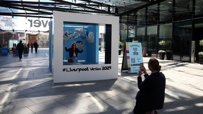 People walk near banners displaying the name of musician Taylor Swift as part of the Taylor Town Trail in anticipation of her arrival, as she will perform three concerts at Anfield Stadium, in Liverpool, Britain June 10, 2024. REUTERS/Molly Darlington