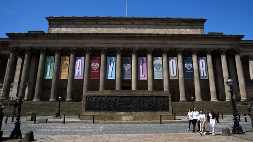 People walk near banners displaying the name of musician Taylor Swift as part of the Taylor Town Trail in anticipation of her arrival, as she will perform three concerts at Anfield Stadium, in Liverpool, Britain June 10, 2024. REUTERS/Molly Darlington