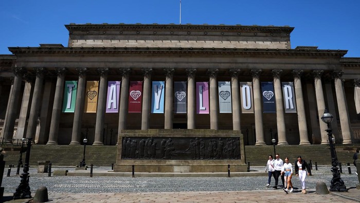 People walk near banners displaying the name of musician Taylor Swift as part of the Taylor Town Trail in anticipation of her arrival, as she will perform three concerts at Anfield Stadium, in Liverpool, Britain June 10, 2024. REUTERS/Molly Darlington