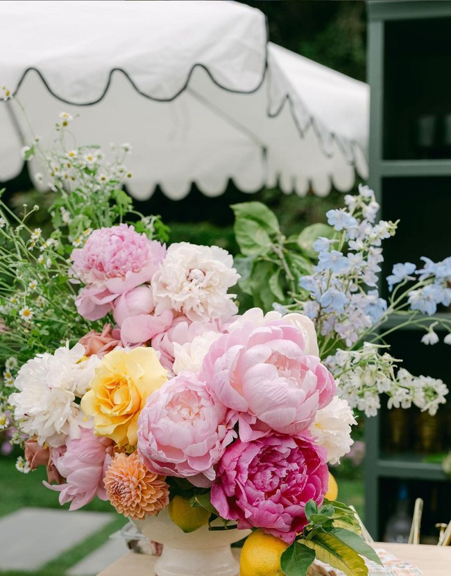 Meja panjang dihiasi pot berisi bunga mawar hingga peony di tengahnya. Perangkat makan dari koleksi Dior menambah kesan mewah. Foto: Instagram/@jillianrosephoto @ladylibertyevents