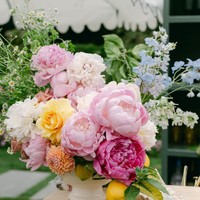 Meja panjang dihiasi pot berisi bunga mawar hingga peony di tengahnya. Perangkat makan dari koleksi Dior menambah kesan mewah. Foto: Instagram/@jillianrosephoto @ladylibertyevents