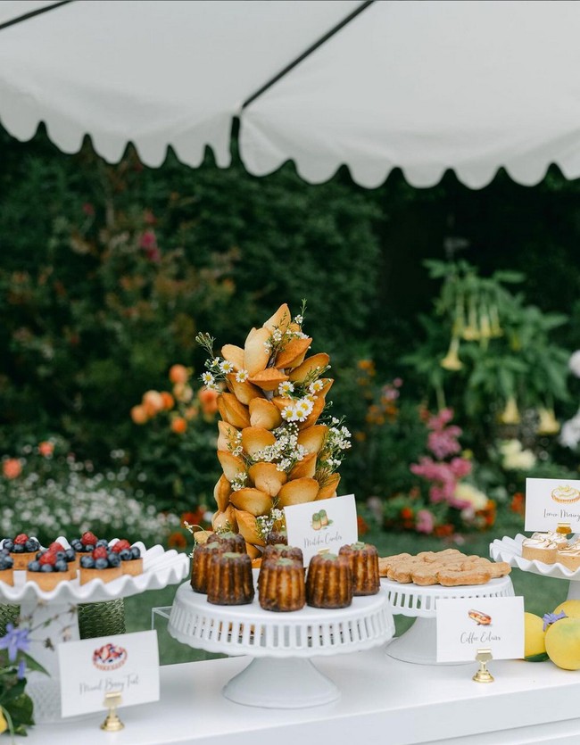 Berbagai penganan manis disajikan, mulai dari macaron, madeleine, taart, eclair juga cannele. Semuanya ditata di atas meja panjang berwarna putih. Foto: Instagram/@jillianrosephoto @ladylibertyevents