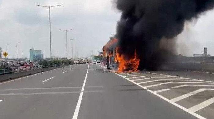 Tragedi Membara: Bus Pariwisata Ter engulfed Flames di Tol Menuju Tanjung Priok, Menyebabkan Kemacetan Parah