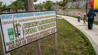 Warga berjalan di dekat papan berisi larangan membuang sampah sembarangan di Taman Huntap Duyu, Palu, Sulawesi Tengah, Selasa (11/6/2024).