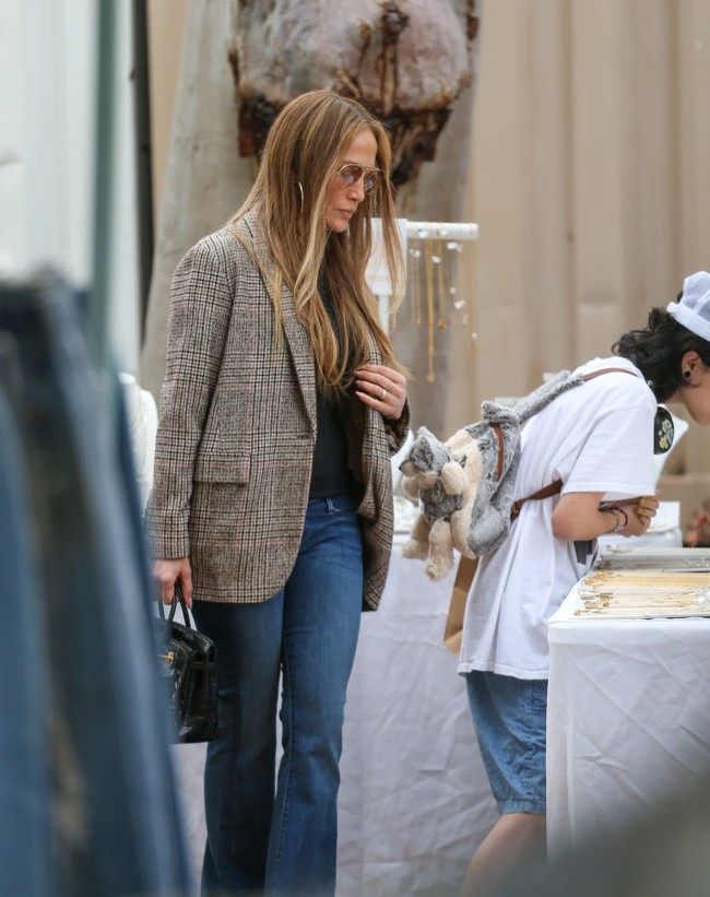 Ia juga menghiasi gayanya dengan kacamata hitam bergaya aviator. Namun, aksesori sesungguhnya yang menyempurnakan look JLo kala itu adalah tas yang ditentengnya. (Foto: Bellocqimages/Bauer-Griffin/GC Images)