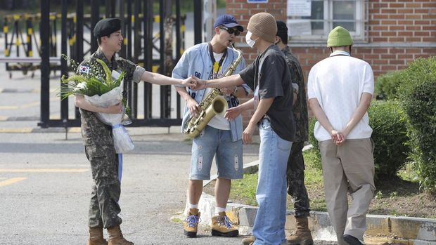 K-pop band BTS's member Jin, left, is greeted by other members j-hope, center, and RM, right, after being discharged from a mandatory military service outside of an army base in Yeoncheon, South Korea, Wednesday, June 12, 2024. (Im Byung-shik/Yonhap via AP)