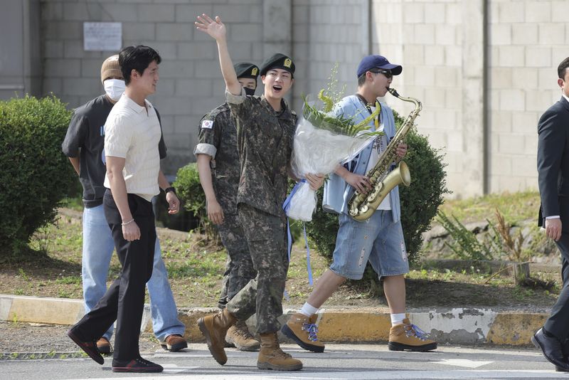 K-pop band BTS's member Jin, left, is greeted by other members j-hope, center, and RM, right, after being discharged from a mandatory military service outside of an army base in Yeoncheon, South Korea, Wednesday, June 12, 2024. (Im Byung-shik/Yonhap via AP)