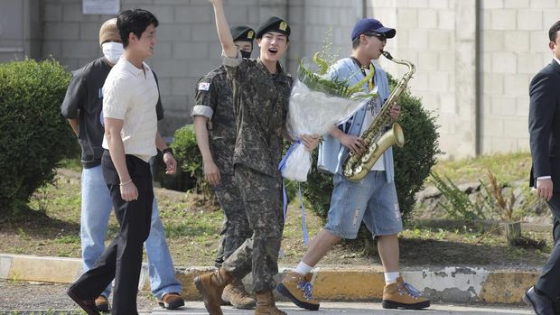 K-pop band BTS's member Jin, left, is greeted by other members j-hope, center, and RM, right, after being discharged from a mandatory military service outside of an army base in Yeoncheon, South Korea, Wednesday, June 12, 2024. (Im Byung-shik/Yonhap via AP)