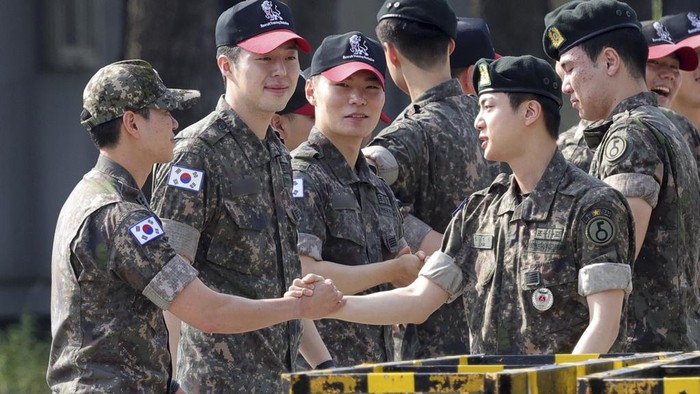 K-pop band BTS's member Jin, left, is greeted by other members j-hope, center, and RM, right, after being discharged from a mandatory military service outside of an army base in Yeoncheon, South Korea, Wednesday, June 12, 2024. (Im Byung-shik/Yonhap via AP)