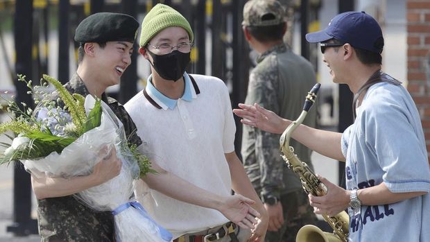 K-pop band BTS's member Jin, left, is greeted by other members j-hope, center, and RM, right, after being discharged from a mandatory military service outside of an army base in Yeoncheon, South Korea, Wednesday, June 12, 2024. (Im Byung-shik/Yonhap via AP)