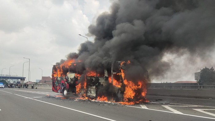 Satu unit bus pariwisata terbakar di Tol Wiyoto Wiyono arah Tanjung Priok, Jakarta Utara. Kebakaran bermula dari pecah ban bus hingga muncul percikan api. (dok Damkar Jaktim)