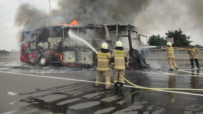 Satu unit bus pariwisata terbakar di Tol Wiyoto Wiyono arah Tanjung Priok, Jakarta Utara. Kebakaran bermula dari pecah ban bus hingga muncul percikan api. (dok Damkar Jaktim)