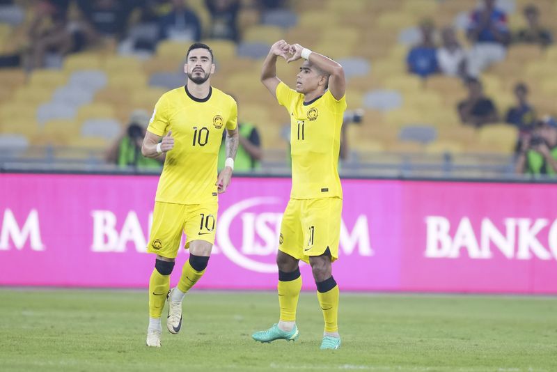 Malaysia's Safawi Rasid, left, reacts after scoring the first goal during a 2026 FIFA World Cup qualifying soccer group D match between Malaysia and Taiwan in Bukit Jalil Stadium in Kuala Lumpur, Malaysia, Tuesday, June 11, 2024. (AP Photo/Vincent Thian)