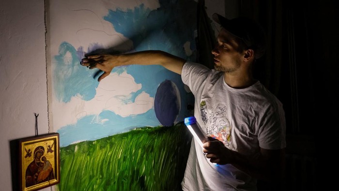 UKRAINE-CRISIS/POWER Ukrainian artist Yevhen Klymenko, a 29-year-old, uses a phone on his balcony during a blackout, amid Russia's attack on Ukraine, in Kyiv, Ukraine, June 5, 2024. REUTERS/Alina Smutko