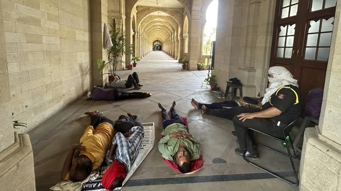 Indian workers rest in the shade of a corridor of the Vijayanagram Hall, now part of the Science Faculty, at Allahabad University on a hot summer afternoon, in Prayagraj, in the northern state of Uttar Pradesh, India, Tuesday, June 11, 2024. (AP Photo/Rajesh Kumar Singh)