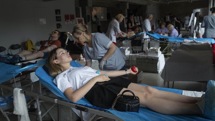 Volunteers donate blood for the army in the art space of a book shop in Kyiv, Ukraine, Tuesday, June 11, 2024. (AP Photo/Efrem Lukatsky)