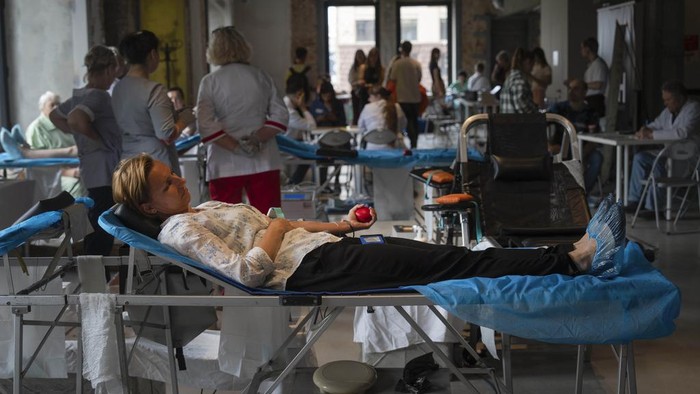 Volunteers donate blood for the army in the art space of a book shop in Kyiv, Ukraine, Tuesday, June 11, 2024.  (AP Photo/Efrem Lukatsky)
