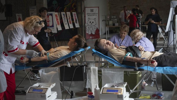 Volunteers donate blood for the army in the art space of a book shop in Kyiv, Ukraine, Tuesday, June 11, 2024.  (AP Photo/Efrem Lukatsky)