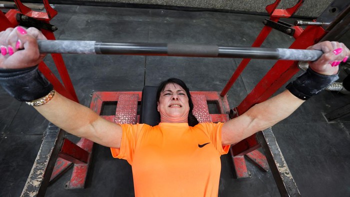 Amani Rabie, 62, an Egyptian grandmother who started training at 54 years old, poses for the camera with her medals from the deadlift and powerlifting competitions while she hopes to continue practising and to win more championships, at a club, in Cairo, Egypt, June 5, 2024. Rabie has participated in local and international tournaments and won 89 gold medals. REUTERS/Mohamed Abd El Ghany