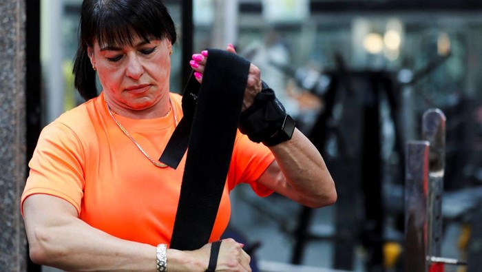 Amani Rabie, 62, an Egyptian grandmother who started training at 54 years old, poses for the camera with her medals from the deadlift and powerlifting competitions while she hopes to continue practising and to win more championships, at a club, in Cairo, Egypt, June 5, 2024. Rabie has participated in local and international tournaments and won 89 gold medals. REUTERS/Mohamed Abd El Ghany