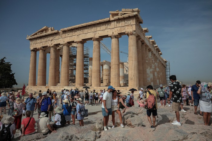 Tourists visit the Parthenon temple atop the Acropolis hill archaeological site before it closes due to a heatwave hitting Athens, Greece, June 13, 2024. REUTERS/Louiza Vradi