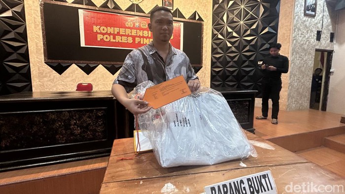 Kasat Reskrim Polres Pinrang Iptu Andi Reza Pahlawan memperlihatkan barang bukti spanduk mantan bupati Pinrang Irwan Hamid yang menjadi sasaran vandalisme.