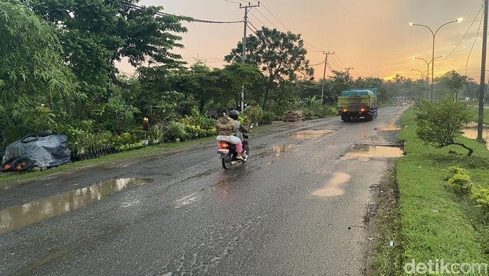 Kondisi Jalan H. M. Noerdin Pandji yang dipenuhi lubang dan lampu mati malam hari
