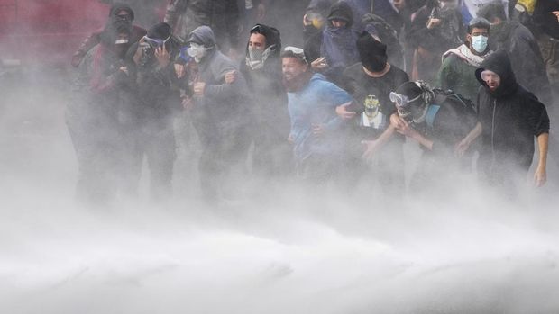 Pengunjuk rasa anti-pemerintah disemprot dengan meriam air polisi di luar Kongres saat anggota parlemen memperdebatkan rancangan undang-undang reformasi yang dipromosikan oleh Presiden Argentina Javier Milei di Buenos Aires, Argentina, Rabu, 12 Juni 2024. (AP Photo/Natacha Pisarenko)