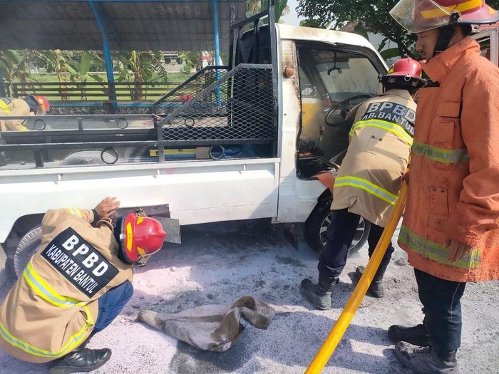 Petugas Damkarmat BPBD Bantul saat memadamkan satu unit pikap yang terbakar di pinggir jalan, Karasan, Palbapang, Bantul, Kamis (13/6/2024).