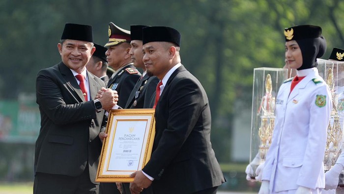 Pj Gubernur Sumatera Utara Hassanudin menyerahjkan penghargaan Tunggul Kecamatan Terbaik Tingkat Provinsi Sumut, kategori kota. (Dok Diskominfo Sumut()