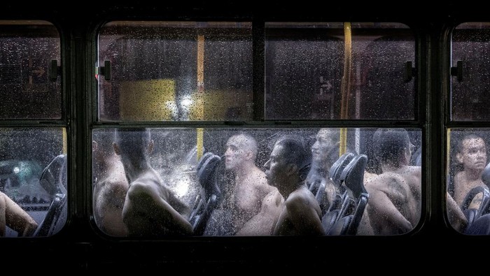 Potret Pemindahan Ribuan Napi Gangster ke Penjara Terbesar di Amerika Gang members walk and sit as they arrive at the Terrorism Confinement Center, as part of a move announced by El Salvador's President Nayib Bukele on social media, in Tecoluca, El Salvador, June 11, 2024. Secretaria de Prensa de la Presidencia//Handout via REUTERS THIS IMAGE HAS BEEN SUPPLIED BY A THIRD PARTY. NO RESALES. NO ARCHIVES