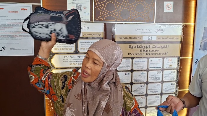 Sumiarsih, jemaah haji asal Solo mengeluarkan isi kopernya saat penimbangan, Kamis (13/6/2024).