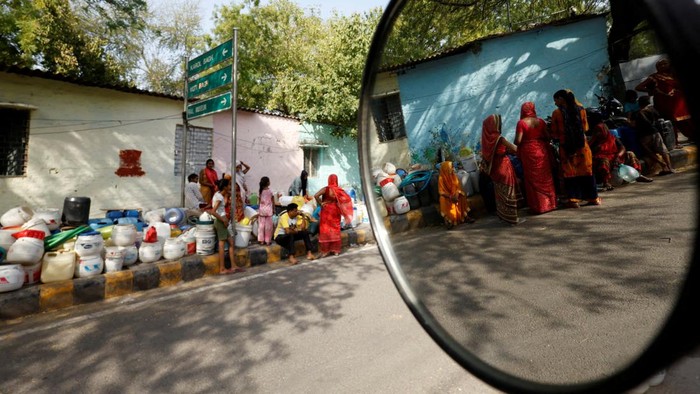 ASIA-WEATHER/INDIA-HEATWAVE Residents use pipes to fill their containers with drinking water from a water tanker during a hot day in New Delhi, India, June 13, 2024. REUTERS/Priyanshu Singh