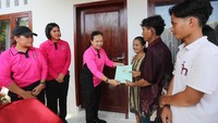 Ernie Agung menyerahkan sertifikat hak milik kepada warga yang rumahnya dibedah. (Dok. Polda Sumut)