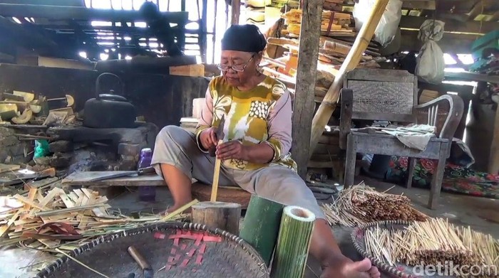 Emak-emak saat membuat tusuk sate di depan kediamannya.