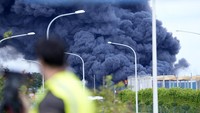 Seorang pria menyaksikan dari jembatan layang saat api berkobar di atap sebuah gudang komersial di bandara kargo Brussels di Brussels, Belgia, Kamis (13/6/2024).