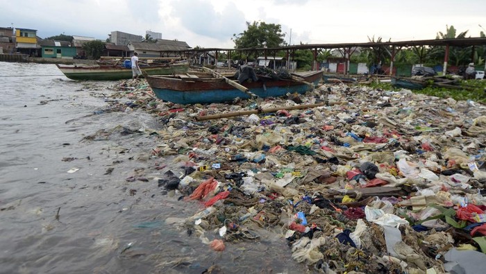 Jorok! Sampah Plastik Cemari Pantai di Bandar Lampung Nelayan menaiki perahu di dekat tumpukan sampah di pantai Sukaraja Bandar Lampung, Lampung, Jumat (14/6/2024). Menurut warga dan nelayan setempat sampah yang menumpuk menutupi pesisir pantai itu sebagian besar berasal dari limbah rumah tangga dan plastik yang terseret arus dan kian menumpuk sehingga mencemari kawasan pantai tersebut. ANTARA FOTO/Ardiansyah/nym.