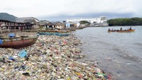 Nelayan menaiki perahu di dekat tumpukan sampah di pantai Sukaraja Bandar Lampung, Lampung, Jumat (14/6/2024).