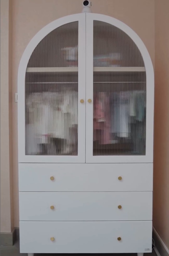 Lemari putih transparan diisi dengan pakaian bayi berwarna pink, biru dan putih yang tertata rapi di gantungan.  Foto: Instagram/@jscmila