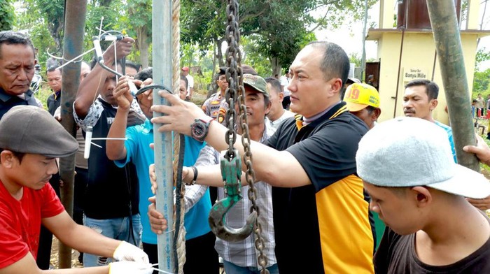 Kapolresta Banyuwangi Kombes Nanang Haryono turut serta memasangkan pipa sumur bor
