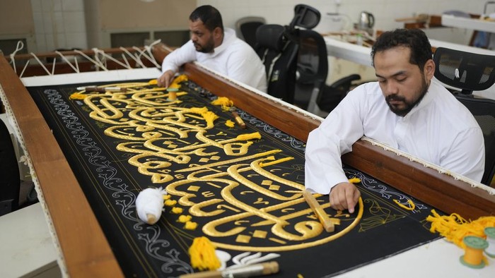 A Saudi man embroiders Islamic calligraphy, using either pure silver threads or silver threads plated with gold, during the final stages in the preparation of a drape, or Kiswa, that covers the Kaaba, a cube-shaped structure at the heart the Grand Mosque, at the Kiswa factory in Mecca, Saudi Arabia, Thursday, June 13, 2024. (AP Photo/Rafiq Maqbool)