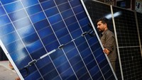 Seorang pria berjalan melewati panel surya yang sedang dijual, di luar toko di pasar yang menjual barang-barang elektronik di Karachi, Pakistan, Selasa (11/6). Pakistan sering mengalami pemadaman listrik, yang disebabkan oleh kesalahan manajemen dan infrastruktur yang tidak memadai.