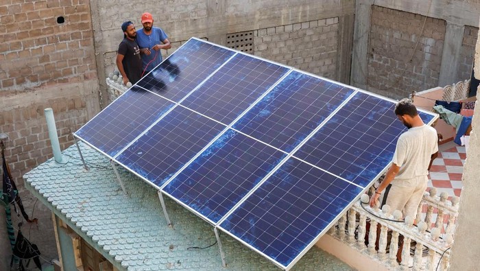 Warga Pakistan Beralih ke Panel Surya gegara Mati Listrik 14 Jam Sehari A worker loads solar panels on a vehicle, outside a shop at a market selling electronic items in Karachi, Pakistan June 11, 2024. REUTERS/Akhtar Soomro
